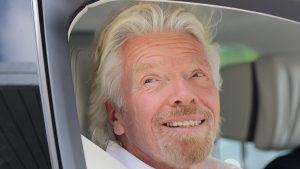 Richard Branson smiling smugly out of a car window